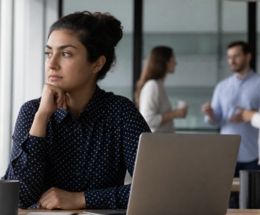 Profissional em sala de reunião aparentando normalidade apesar da pressão emocional no trabalho