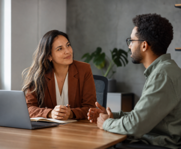 Líder e pessoa da equipe em reunião one-on-one para feedback e escuta ativa