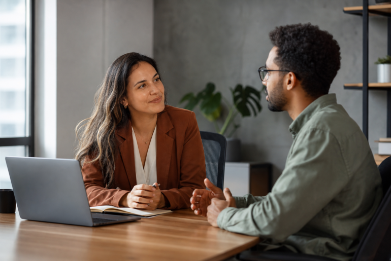 Líder e pessoa da equipe em reunião one-on-one para feedback e escuta ativa