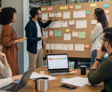 Equipe organiza cartões de projetos e habilidades em mural para testar talent marketplace interno