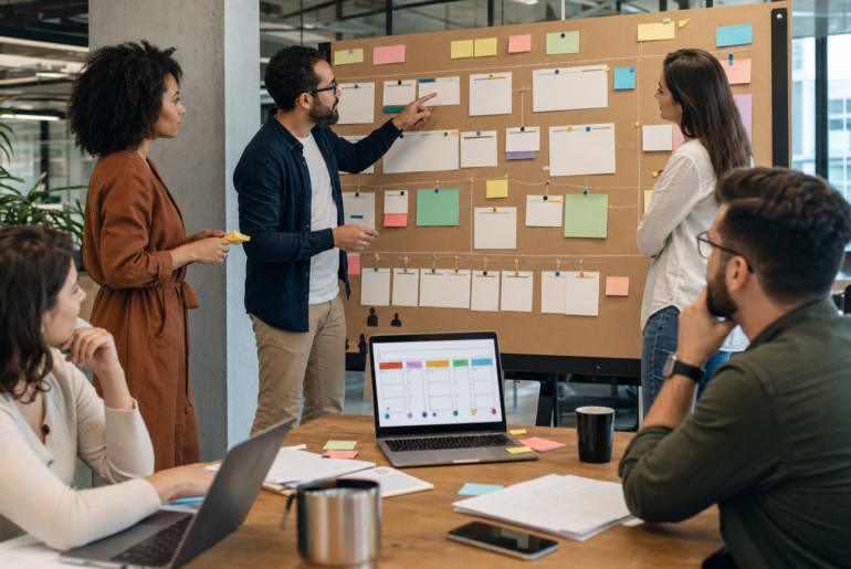 Equipe organiza cartões de projetos e habilidades em mural para testar talent marketplace interno