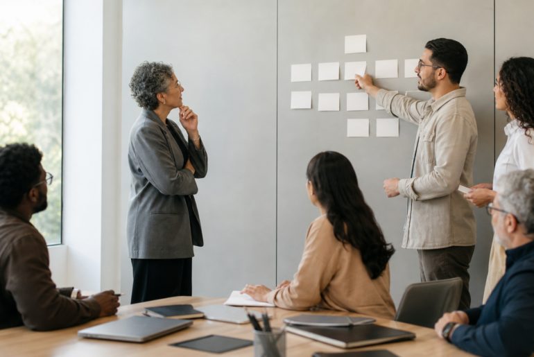 Equipe de RH e lideranças reorganiza prioridades em quadro visual durante conversa sobre mudança organizacional